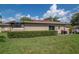 Exterior shot of home with a well maintained lawn and tidy hedges along the perimeter at 2444 Laurelwood Dr # A, Clearwater, FL 33763