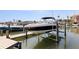 A boat on a lift at a private dock of a waterfront home with direct access to the Gulf at 253 Boca Ciega Dr, Madeira Beach, FL 33708