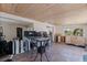 Open-concept living room with tile floors, wood ceiling, and natural light in need of renovation at 253 Boca Ciega Dr, Madeira Beach, FL 33708