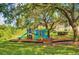 Exterior view of colorful community playground surrounded by mature shade trees at 2690 Coral Landings Blvd # 217, Palm Harbor, FL 34684
