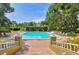 Beautiful pool area with lounge chairs, mature trees, and manicured greenery at 2690 Coral Landings Blvd # 217, Palm Harbor, FL 34684