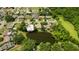 Community aerial view with mature trees and a large pond at 3010 Grand View Ave, Clearwater, FL 33759