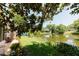 Backyard view featuring a tranquil pond, lush lawn, and a cozy seating area on the patio at 3010 Grand View Ave, Clearwater, FL 33759
