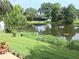 Lush backyard with mature trees and a serene lake view at 3010 Grand View Ave, Clearwater, FL 33759