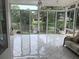 Bright sunroom with tile flooring and sliding glass doors overlooking a serene lake view at 3010 Grand View Ave, Clearwater, FL 33759