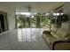 Bright sunroom with tile flooring and sliding glass doors overlooking a serene lake view at 3010 Grand View Ave, Clearwater, FL 33759