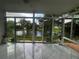 Bright sunroom with tile flooring and sliding glass doors overlooking a serene lake view at 3010 Grand View Ave, Clearwater, FL 33759
