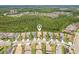 An aerial view of a home in a tree-filled neighborhood with a community lake at 30764 Lindentree Dr, Wesley Chapel, FL 33543