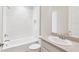 Bathroom featuring a tub with a shower, white vanity, and modern fixtures at 30764 Lindentree Dr, Wesley Chapel, FL 33543