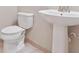 Well-lit bathroom featuring a classic white toilet and pedestal sink at 30764 Lindentree Dr, Wesley Chapel, FL 33543