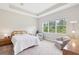 Bright and spacious bedroom with a tray ceiling and large window overlooking the landscape at 30764 Lindentree Dr, Wesley Chapel, FL 33543