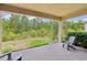 View of a covered patio with brick flooring, chairs and a lovely view of nature at 30764 Lindentree Dr, Wesley Chapel, FL 33543