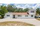 Quaint two-story home featuring a spacious front yard and a long driveway with car port at 311 Jeanal Pl, Tampa, FL 33612