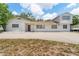 Quaint two-story home featuring a spacious front yard and a long driveway with car port at 311 Jeanal Pl, Tampa, FL 33612
