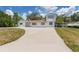 Quaint two-story home featuring a spacious front yard and a long driveway with car port at 311 Jeanal Pl, Tampa, FL 33612