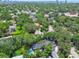 An aerial view of homes nestled among mature green trees with a city skyline in the distance at 3209 W Morrison Ave, Tampa, FL 33629