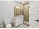 Bathroom vanity with white cabinets, quartz counters, updated fixtures, and a seamless glass shower at 3209 W Morrison Ave, Tampa, FL 33629