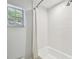 Bathroom featuring shower over tub, decorative tile, and natural light at 3209 W Morrison Ave, Tampa, FL 33629