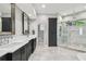Bright bathroom featuring a double vanity, walk-in shower, marble floors and a tall cabinet for ample storage at 3209 W Morrison Ave, Tampa, FL 33629