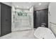 Bathroom boasting a soaking tub, walk-in shower with glass door, marble floors, and custom cabinets at 3209 W Morrison Ave, Tampa, FL 33629