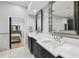Bathroom with double vanity, quartz countertop, framed mirrors, and view into the Main Bedroom at 3209 W Morrison Ave, Tampa, FL 33629
