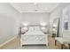 Bedroom showcasing a white bed frame, neutral walls, ceiling fan, and a full-length mirror at 3209 W Morrison Ave, Tampa, FL 33629