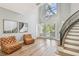 Bright foyer with two-story ceilings, light wood floors, tufted leather chairs and curved staircase at 3209 W Morrison Ave, Tampa, FL 33629