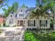 Charming white brick two-story home with landscaped yard, palm trees, and black shutters at 3209 W Morrison Ave, Tampa, FL 33629