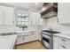 Gourmet kitchen with white cabinets, marble countertops, farmhouse sink and stainless steel appliances at 3209 W Morrison Ave, Tampa, FL 33629