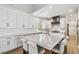 Modern kitchen featuring an island with white marble countertop, white cabinets and hardwood floors at 3209 W Morrison Ave, Tampa, FL 33629