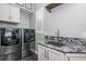 Laundry room featuring stainless steel washer/dryer and granite countertops at 3209 W Morrison Ave, Tampa, FL 33629