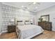 Tranquil main bedroom featuring accent wallpaper, wood floors, and abundant natural light at 3209 W Morrison Ave, Tampa, FL 33629
