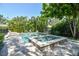 Backyard oasis featuring a luxurious pool with a spa, lush landscaping, and sun loungers; ideal for relaxation and entertainment at 3209 W Morrison Ave, Tampa, FL 33629