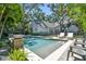 Beautiful backyard featuring a sparkling pool with spa, lush landscaping, and a serene outdoor setting; perfect for relaxation at 3209 W Morrison Ave, Tampa, FL 33629