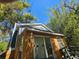Exterior view of home with brown siding, slider door, and blue trim against a clear sky surrounded by bamboo at 32348 Marchmont Cir, Dade City, FL 33523