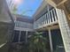 Exterior view of a two-story home featuring screened in balconies and a landscaped courtyard at 32348 Marchmont Cir, Dade City, FL 33523