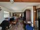 Open-concept living room with wood beams, dining area, and a glimpse into the kitchen at 32348 Marchmont Cir, Dade City, FL 33523