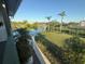 Scenic backyard with a tranquil pond view, verdant landscaping, and palm trees provide a relaxing outdoor oasis at 3338 Fernleaf Dr, Hernando Beach, FL 34607