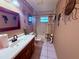 Bathroom featuring white tile floor, vanity, toilet and shower with wall decor at 3338 Fernleaf Dr, Hernando Beach, FL 34607