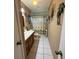 Bathroom featuring white tile floor, vanity, toilet and shower with palm tree decor at 3338 Fernleaf Dr, Hernando Beach, FL 34607