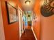 View of the orange interior hallway with hardwood floors leading to the living room at 3338 Fernleaf Dr, Hernando Beach, FL 34607