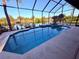 Sparkling screened-in pool and spa area with scenic water views offers a refreshing escape and outdoor enjoyment at 3338 Fernleaf Dr, Hernando Beach, FL 34607