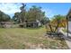 Large grassy backyard featuring mature trees, shed, landscaping, with fence line at 3405 E Diana St, Tampa, FL 33610