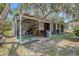 View of the home's backyard featuring a covered area, storage shelves, and open space at 3405 E Diana St, Tampa, FL 33610
