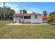 The exterior showcases a cozy home with lattice accents, a pergola, patio, red trim, and well-kept lawn at 3405 E Diana St, Tampa, FL 33610