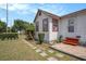 Charming home featuring white siding, red trim, a stone walkway and green shrubs at 3405 E Diana St, Tampa, FL 33610