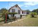 Quaint home boasting a neat yard, white exterior with red accents, and charming landscaping at 3405 E Diana St, Tampa, FL 33610