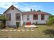 Charming home showcasing a white exterior with red trim and a well-maintained front lawn at 3405 E Diana St, Tampa, FL 33610