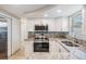 Modern kitchen featuring white cabinets, stainless steel appliances, granite countertops, and a stylish backsplash at 3445 Pinehurst Dr, Holiday, FL 34691