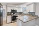 Modern kitchen featuring granite countertops, stainless steel appliances, and white cabinets at 3445 Pinehurst Dr, Holiday, FL 34691